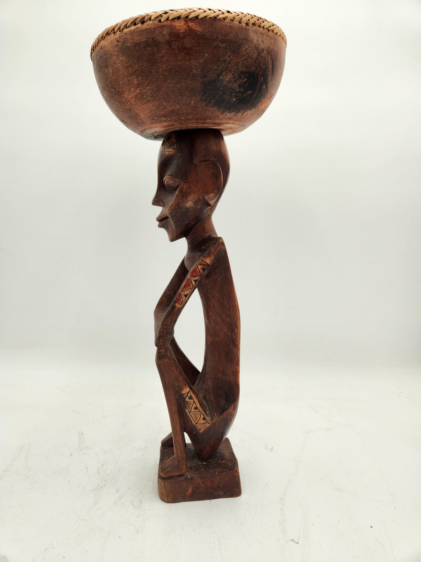 Primitive wood carving of a woman with a cup for head