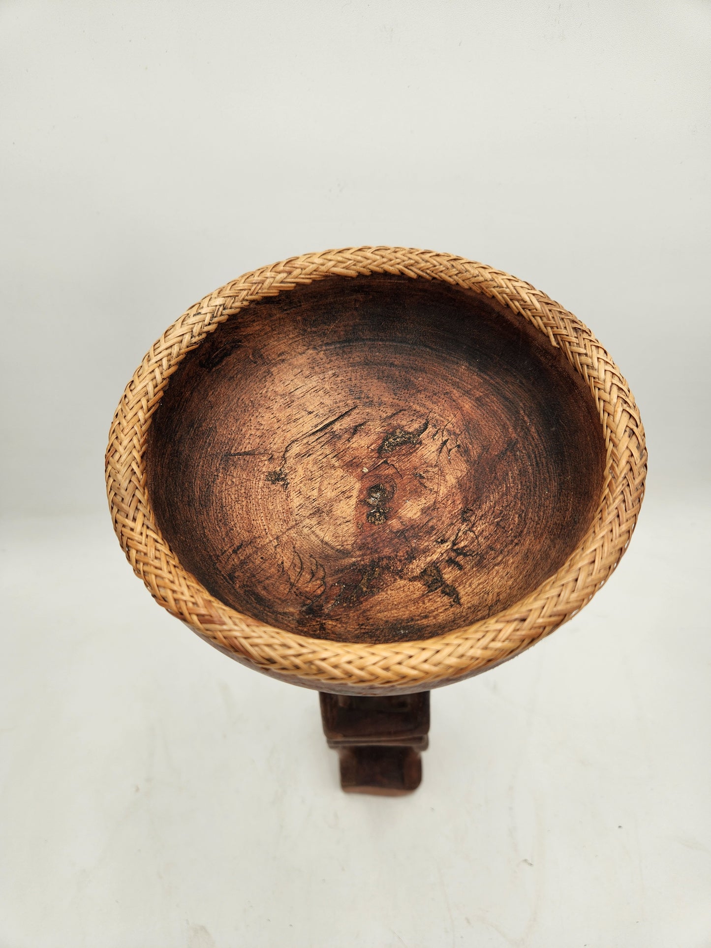 Primitive wood carving of a woman with a cup for head
