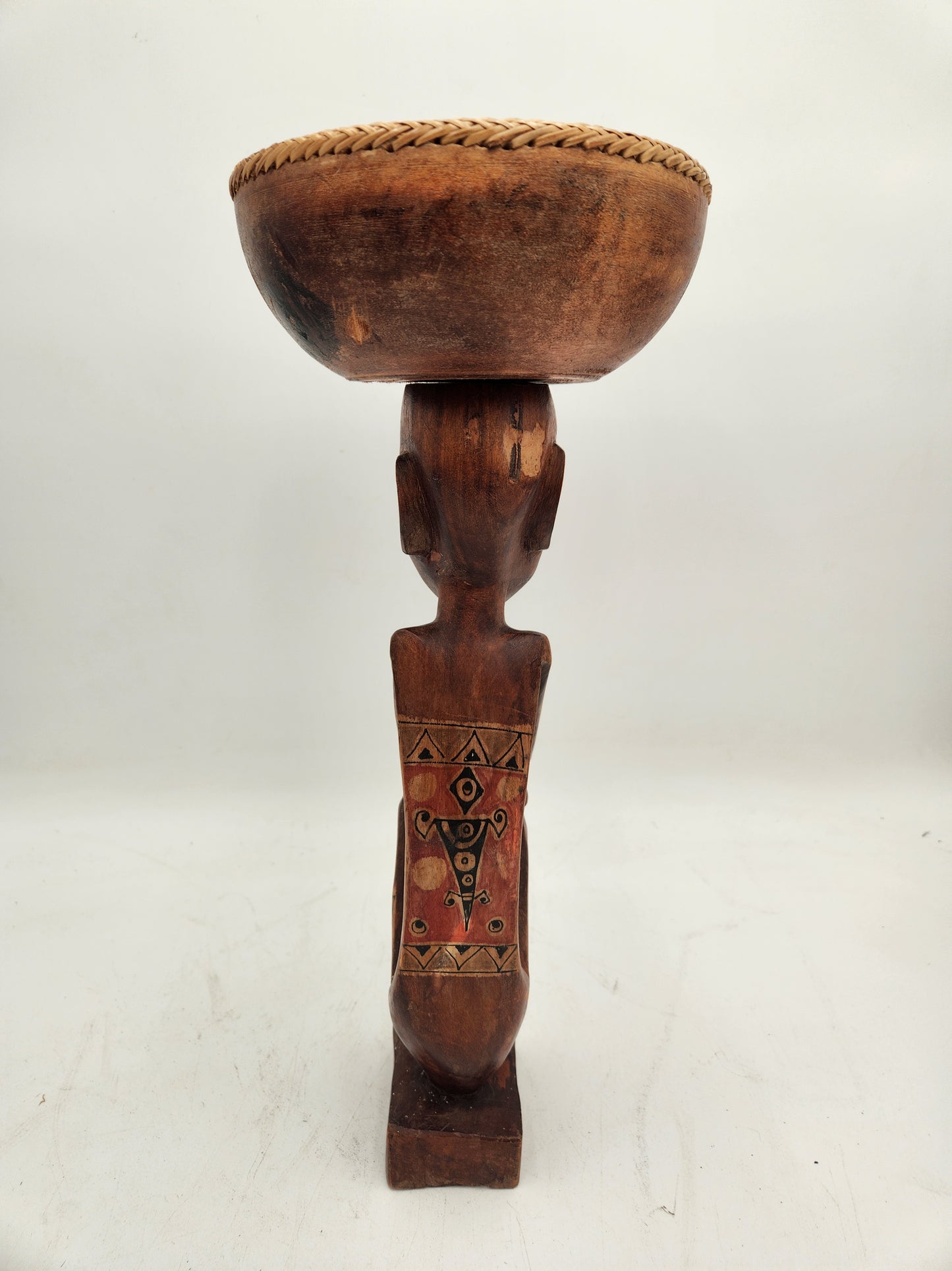 Primitive wood carving of a woman with a cup for head